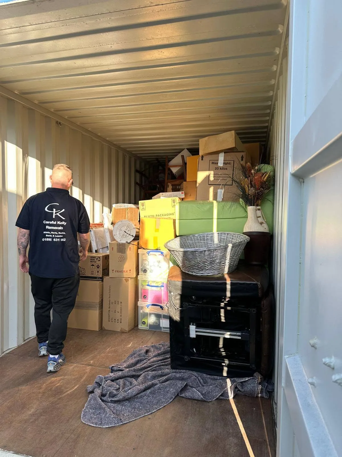 Careful Kelly Removals crew member walking through a loaded storage container